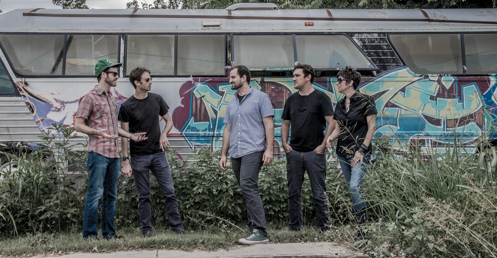 band hanging out in front of art bus